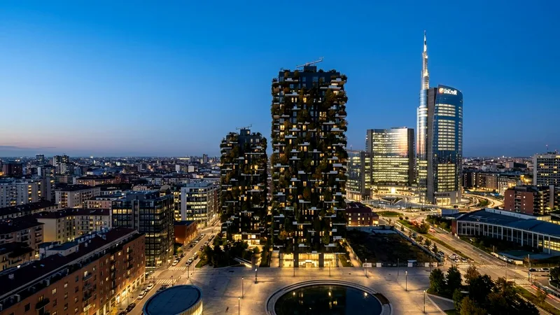 Bosco Verticale tree-covered towers and UniCredit tower in Milan's Porta Nuova at blue hour.